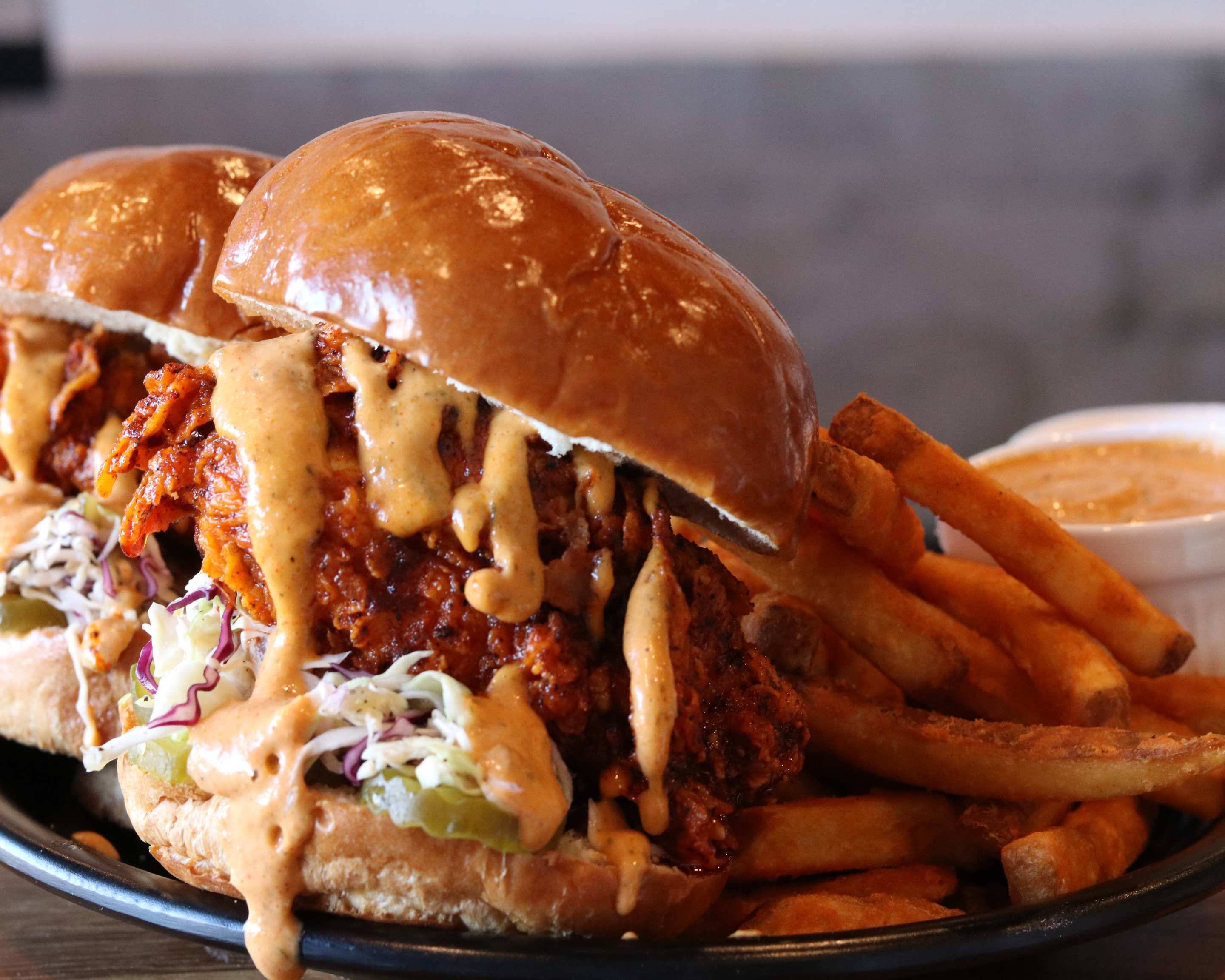 Stark's hot chicken sandos with slaw, pickles and comeback sauce, served with seasoned fries